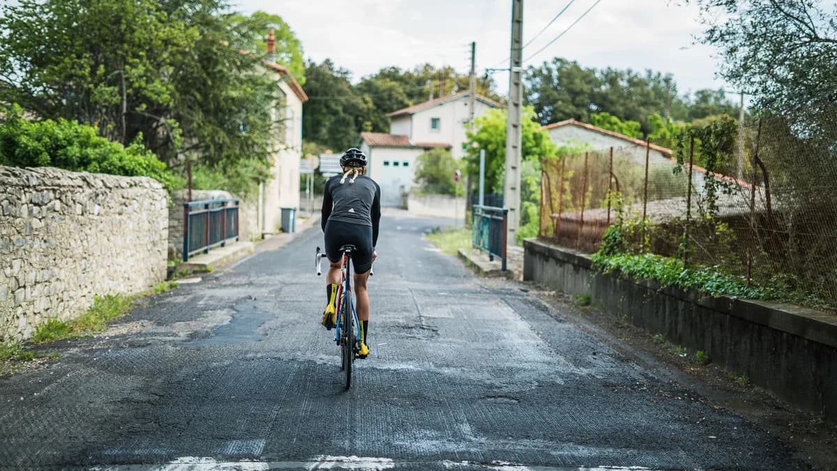 Cyclist enjoying a peaceful ride through a charming suburban neighborhood, perfect for fitness and leisure.