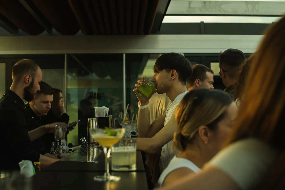 A bustling bar scene with people enjoying drinks and engaging socially.