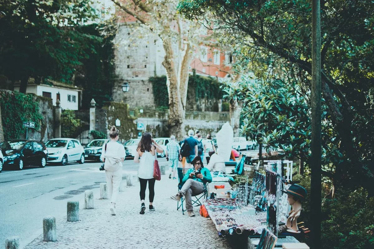 A bustling urban street with vendors displaying crafts and tourists exploring, showcasing local culture.