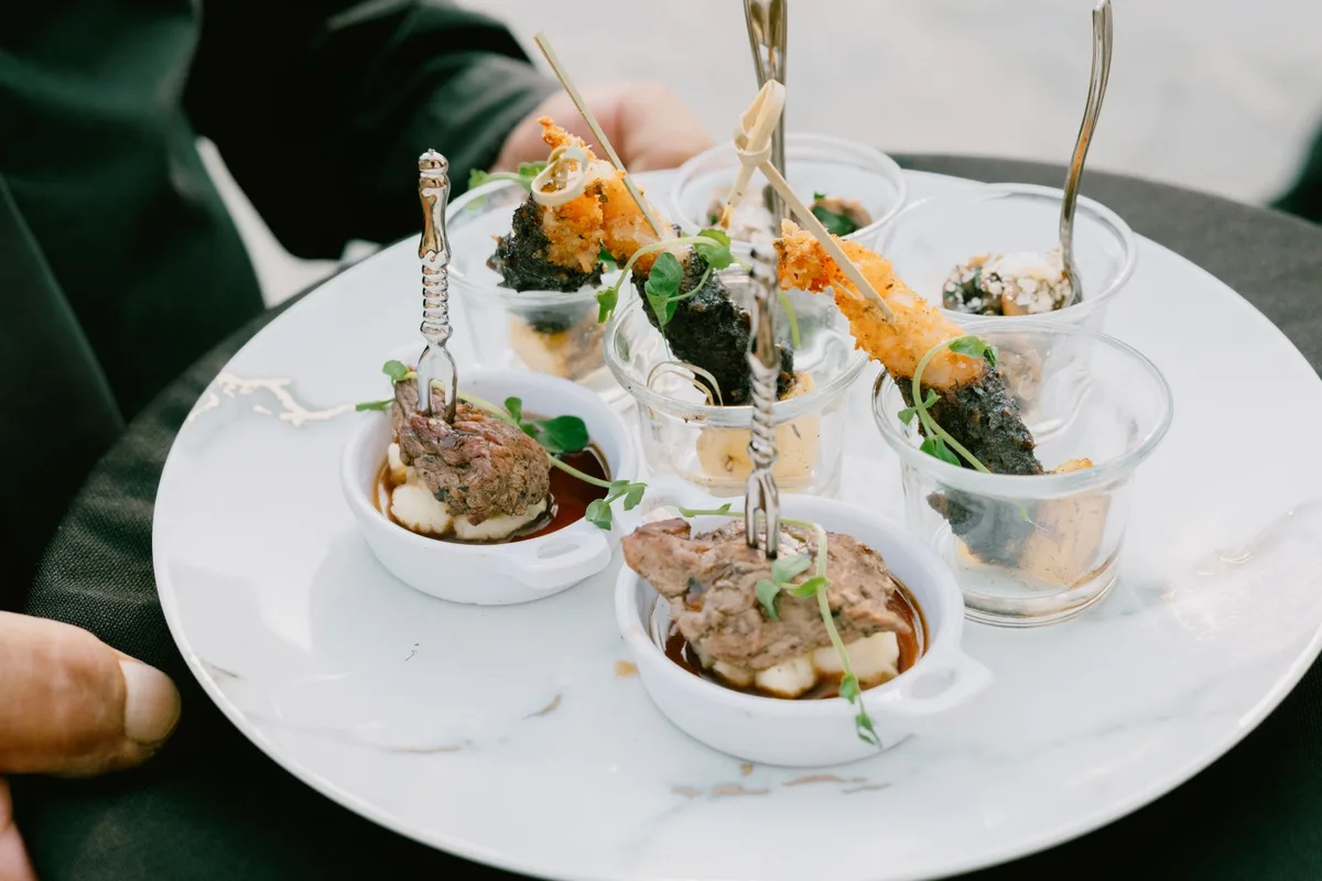 A beautifully presented plate of gourmet appetizers featuring meats and seafood in elegant glassware.