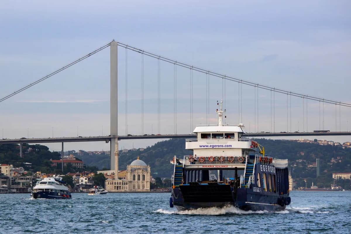 Ferries crossing the Bosphorus under the iconic İstanbul bridge.