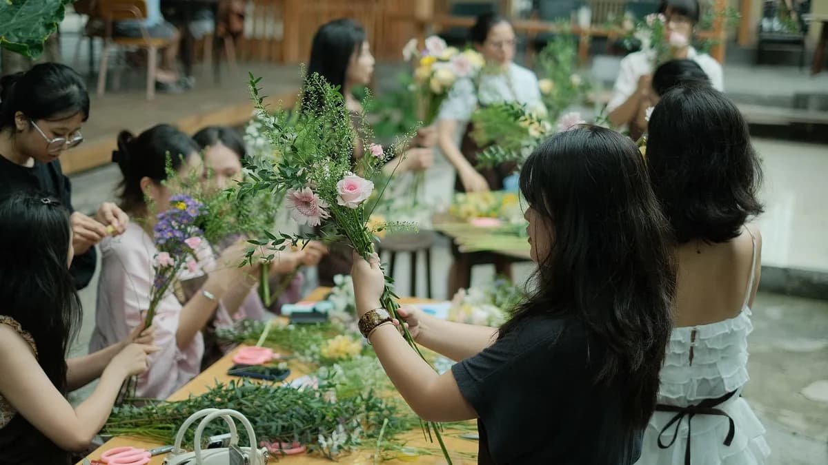 A group of women arranging flowers at a workshop, fostering creativity and teamwork.
