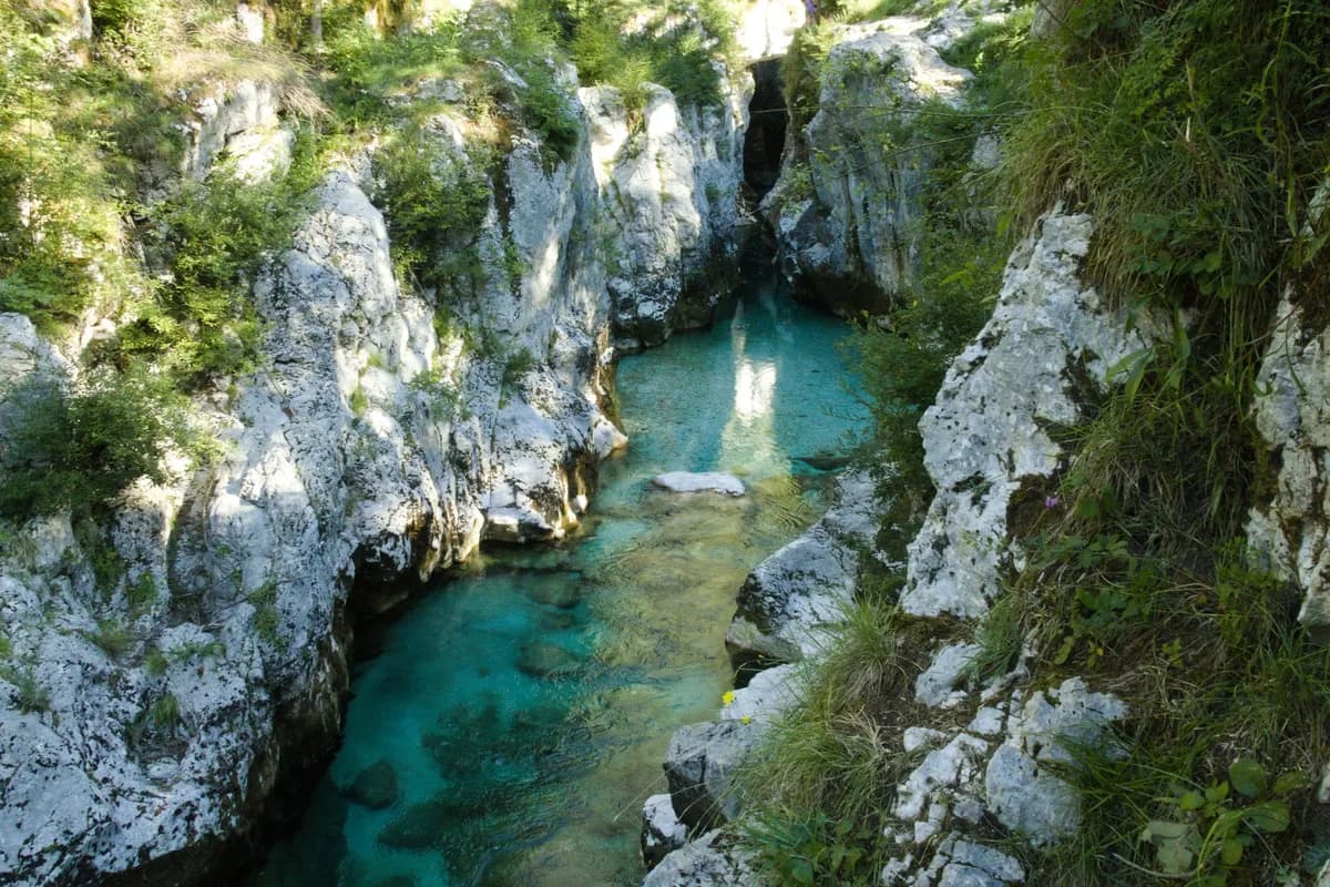 A breathtaking view of a turquoise river winding through a rocky canyon in Bovec, Slovenia.