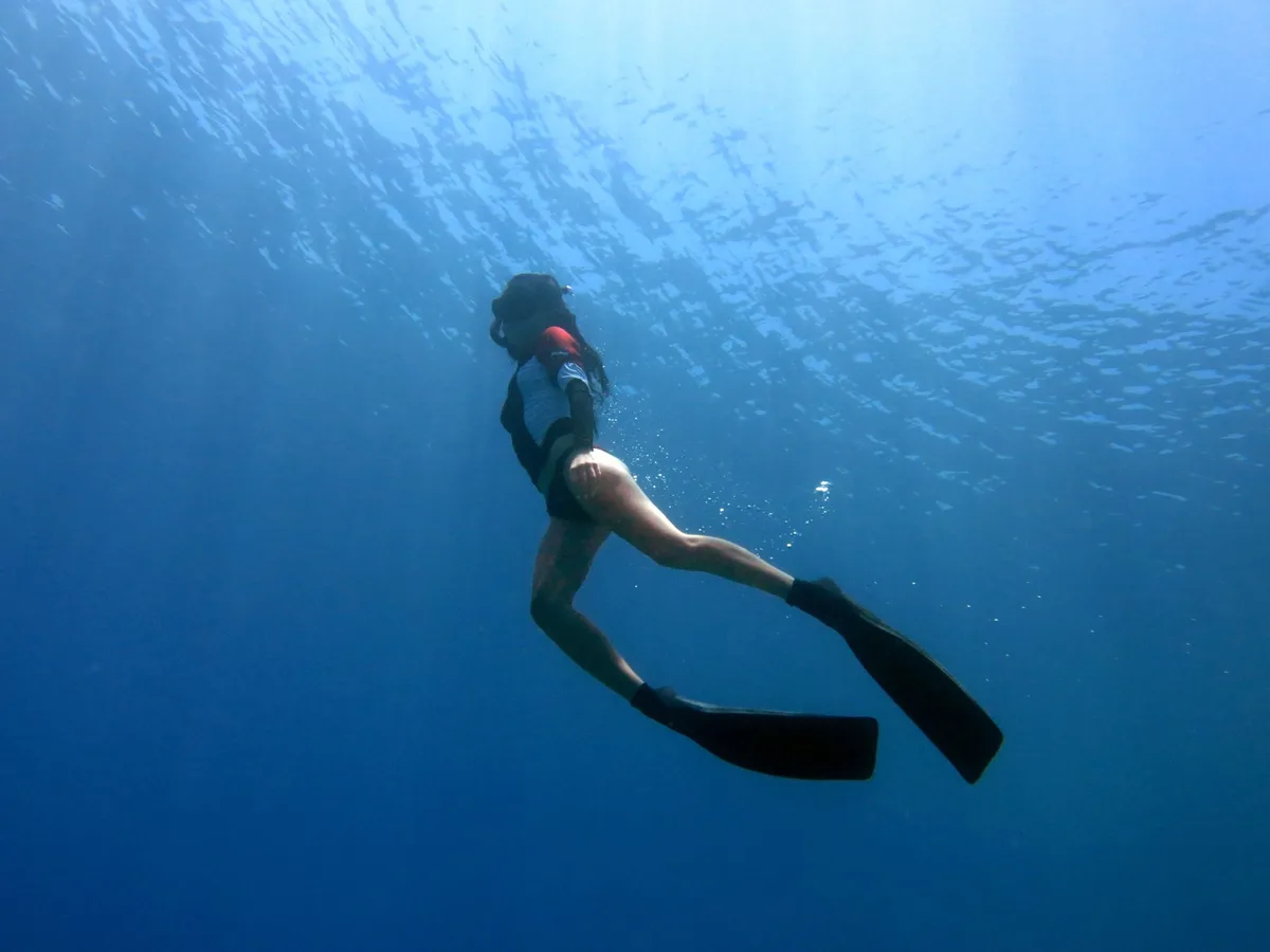 Freediver exploring the deep blue sea in Bodrum, Türkiye, showcasing the tranquility of underwater adventure.