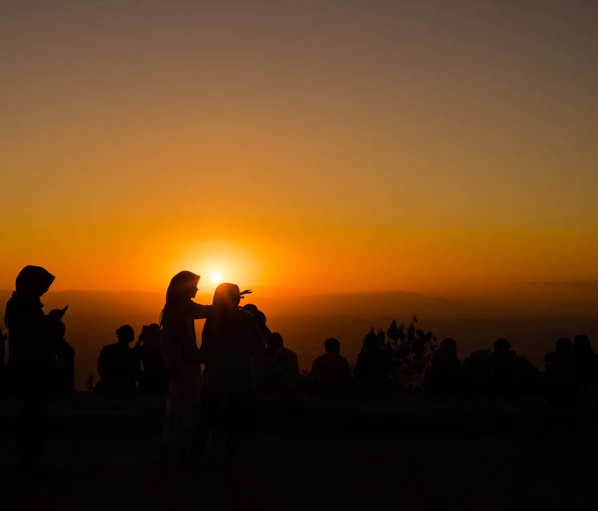 A serene sunset scene with silhouetted people enjoying the view.
