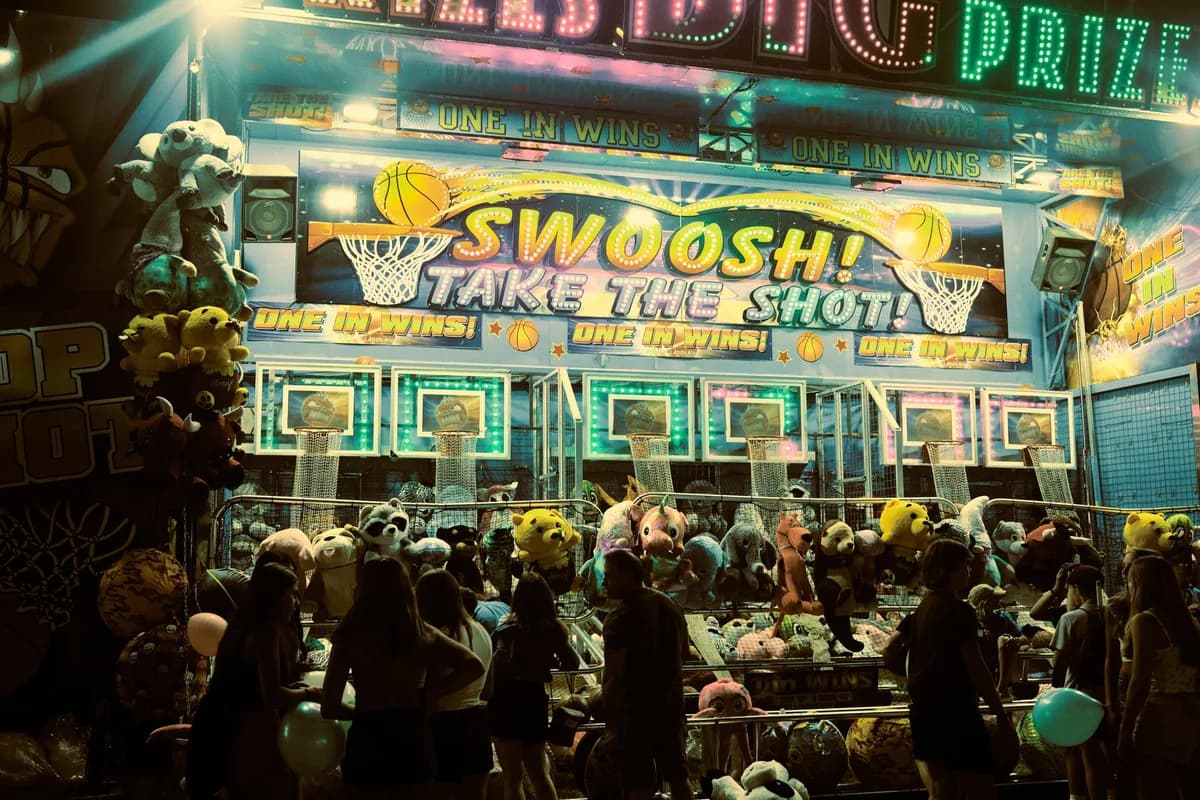 A lively carnival booth at night in Arlington Heights with people enjoying games.