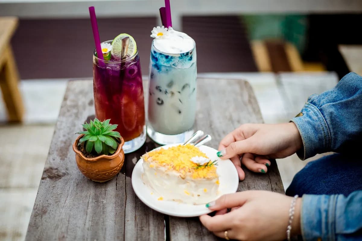 A vibrant dessert scene featuring drinks and cake on a rustic table. Perfect for food themes.