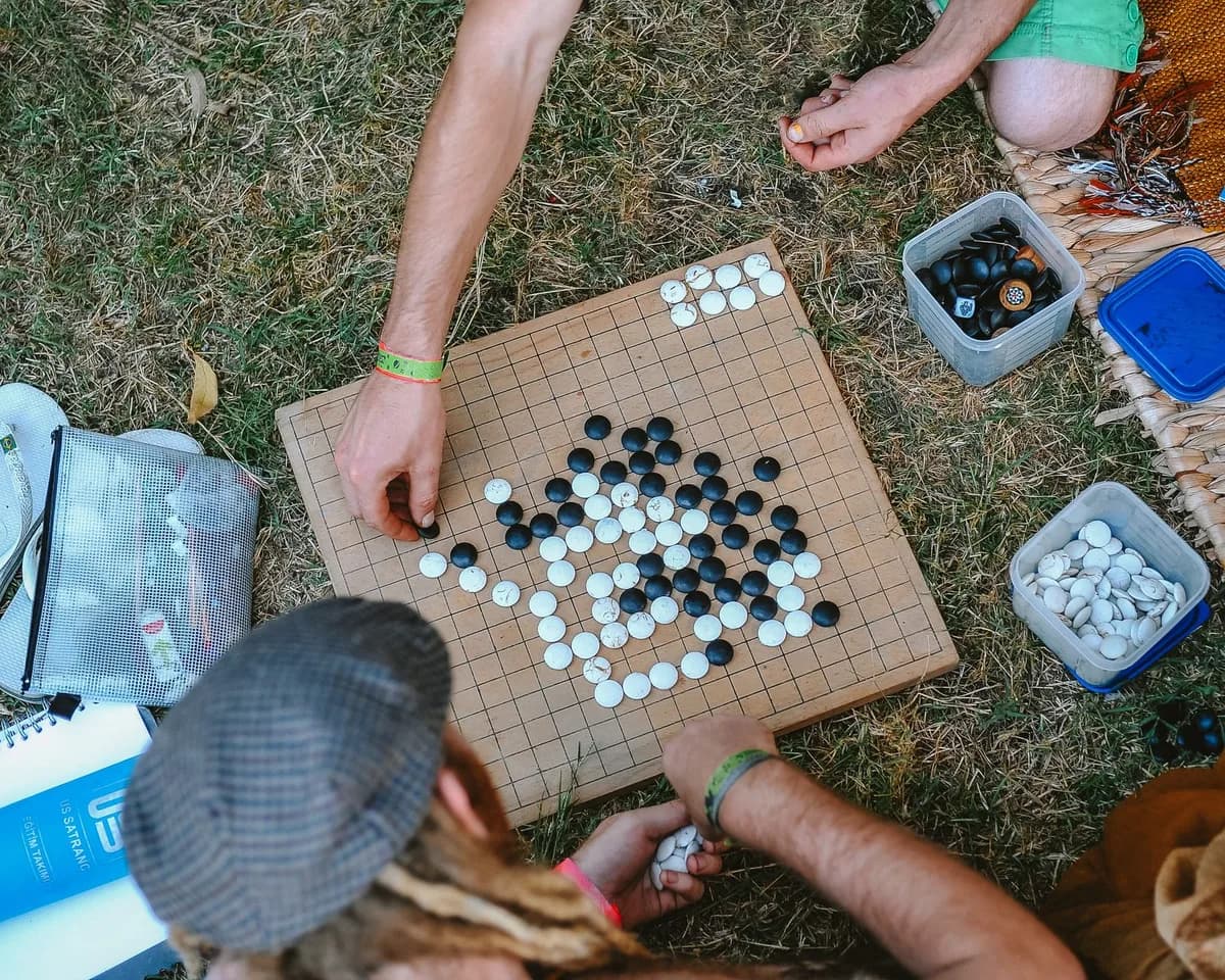 Aerial view of people playing Go outdoors, showcasing a casual game setup on a grassy lawn.