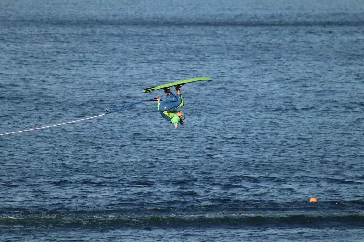 A thrilling moment of a person performing an aerial waterski trick on a sunny day.