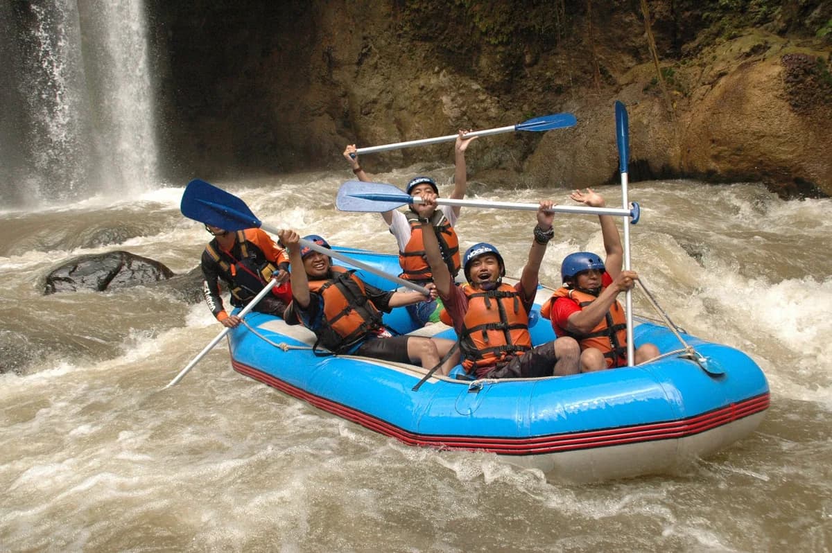 Group enjoying a thrilling white water rafting adventure amidst stunning waterfalls and rapids.
