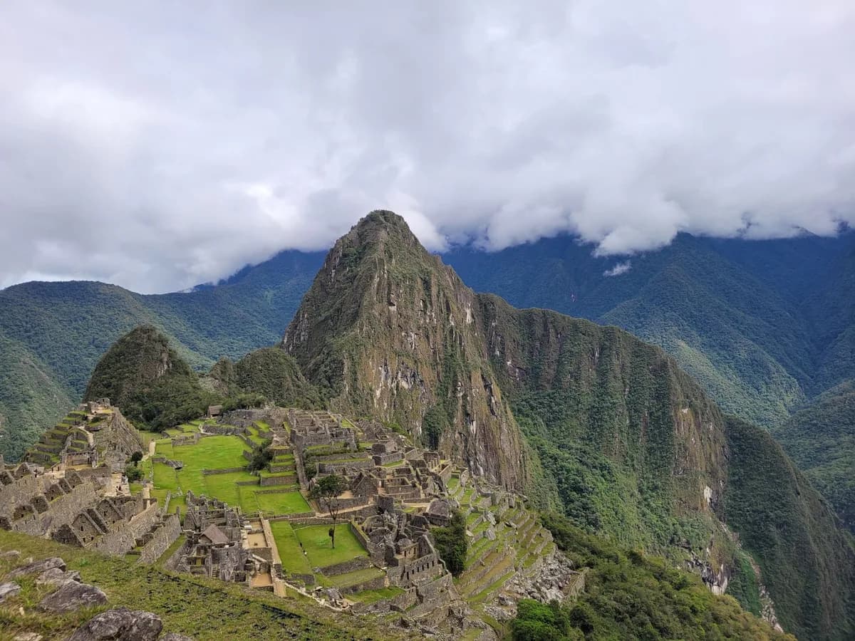 Stunning aerial view of the historic Machu Picchu in the Andes mountains, showcasing its ancient architecture and lush surroundings.