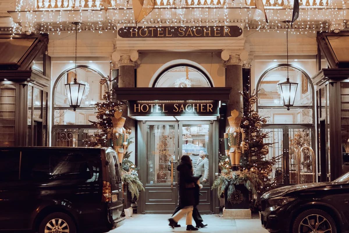 Front view of Hotel Sacher in Vienna, Austria adorned with festive Christmas lights and decorations.