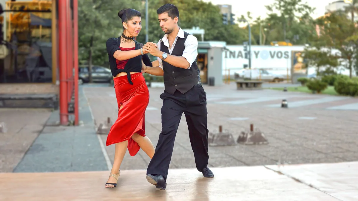 A couple gracefully performing tango on the streets of Buenos Aires, capturing the essence of dance and culture.