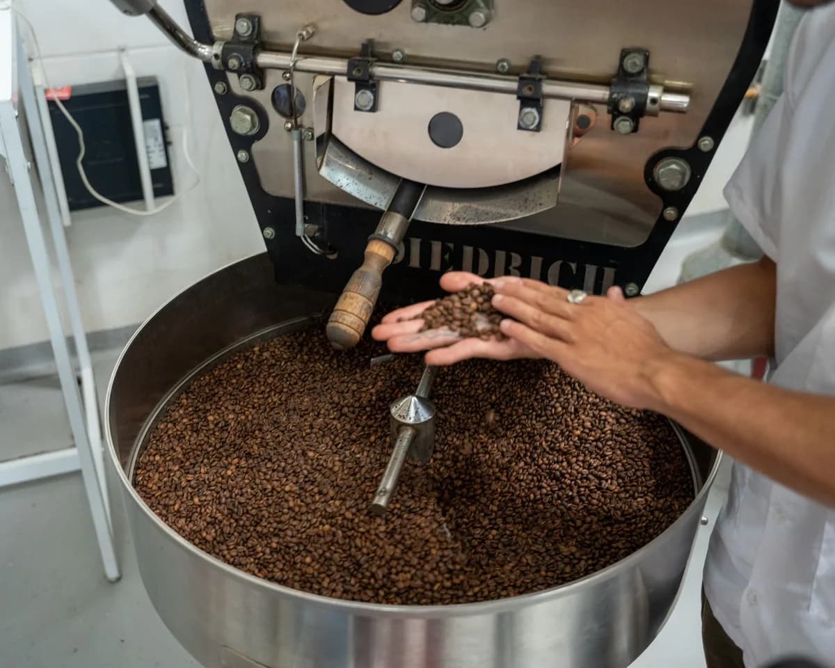 Close-up of coffee beans being roasted in a large industrial roaster, showcasing the process.