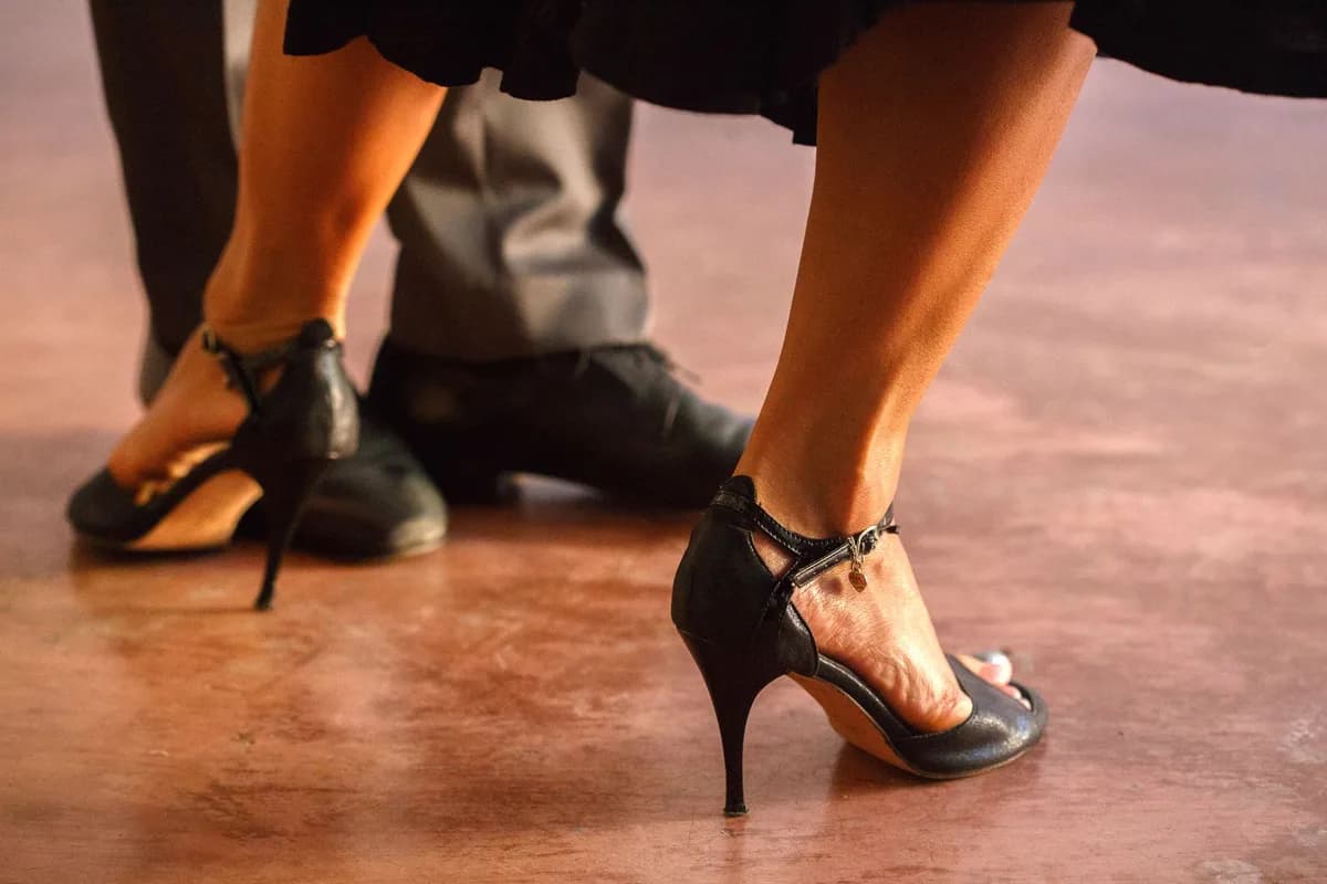 Close-up of a couple's feet dancing in elegant footwear, highlighting the grace of the dance.