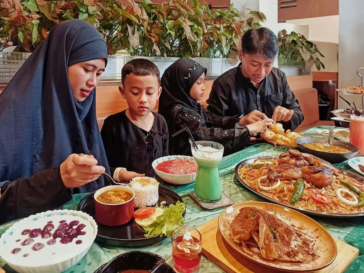 A family enjoys a meal of traditional Indonesian dishes at a restaurant in Jawa Barat.