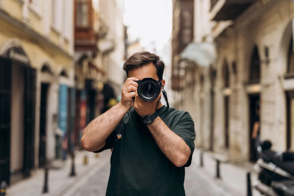 Man photographing in an Istanbul alley, showcasing urban street vibes and cultural architecture.