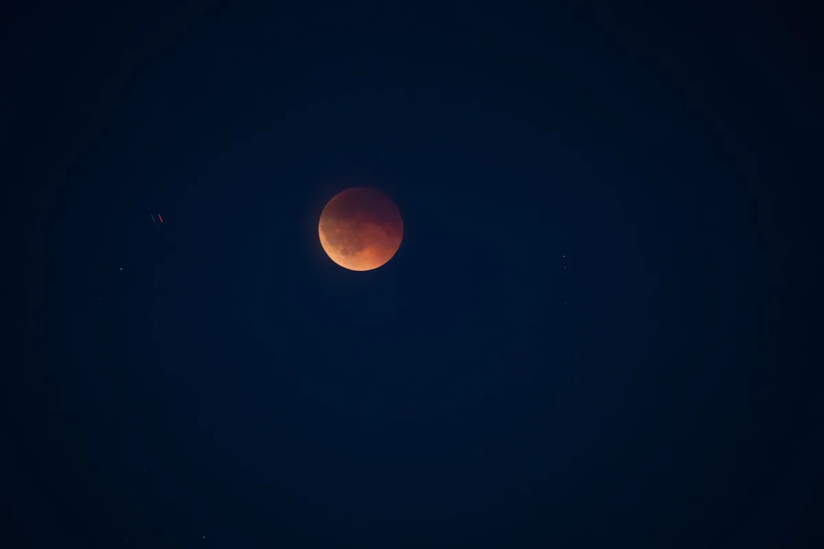 A breathtaking view of a lunar eclipse captured in the starry night sky above Würzburg, Germany.