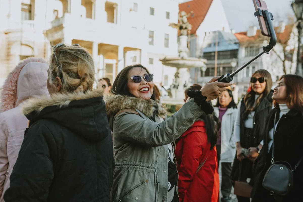 A group of tourists enjoys a city tour, capturing memories with a selfie in an urban setting.