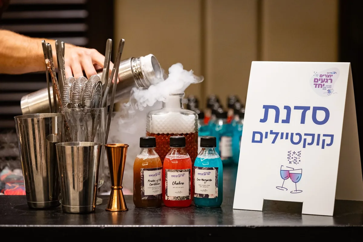 Cocktail mixing setup with ingredients and equipment at a workshop.