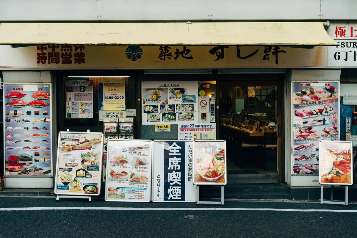Front view of a traditional sushi restaurant in Tokyo with vibrant menu displays.