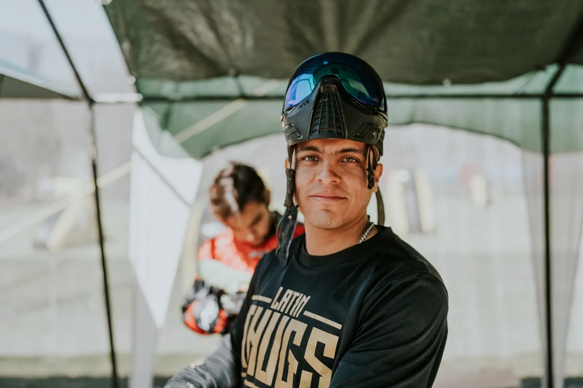Close-up of a paintball player in protective gear outdoors, ready for action.