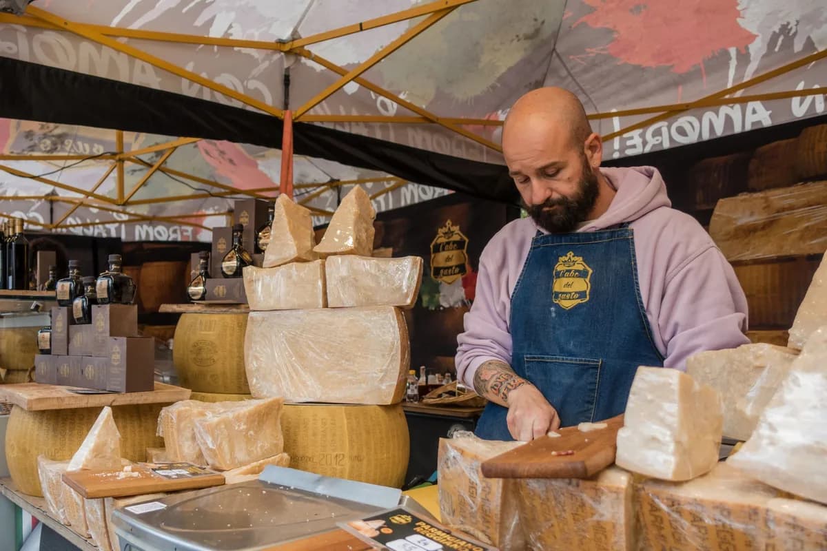 A vendor prepares authentic Italian cheese at a bustling market stall.