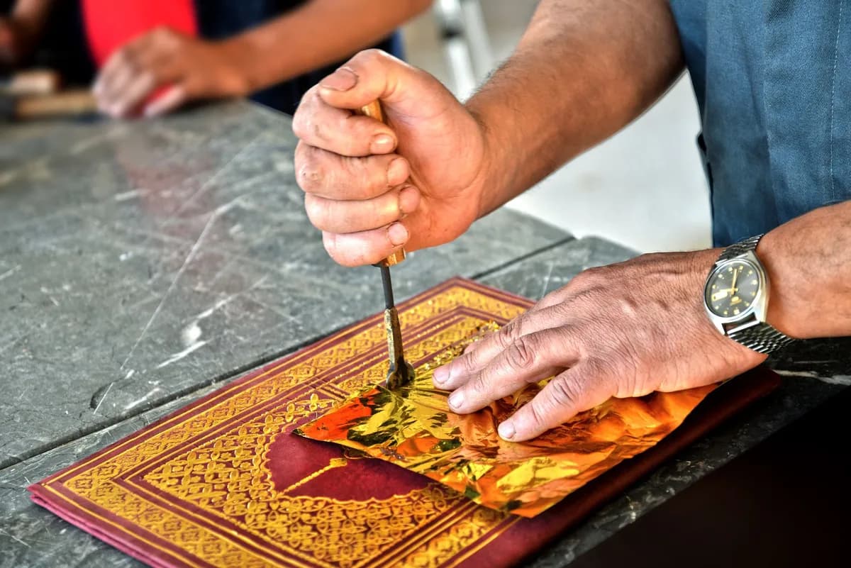 Close-up of an artisan crafting intricate designs in Fès, Morocco, showcasing cultural heritage.