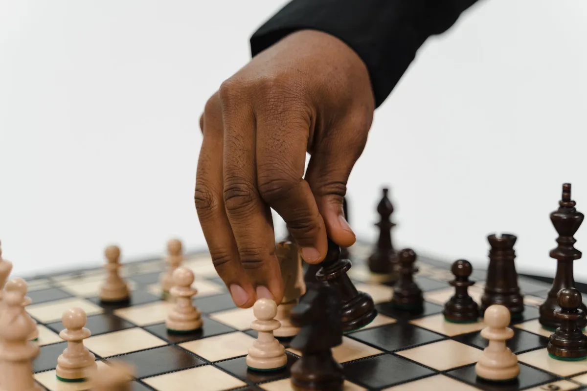 Close-up of a hand making a chess move, highlighting strategic gameplay and decision-making.