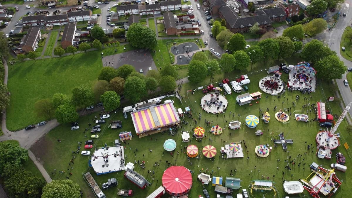 A vibrant aerial shot of a funfair in Houghton Regis, showcasing various rides and activities on a sunny day.