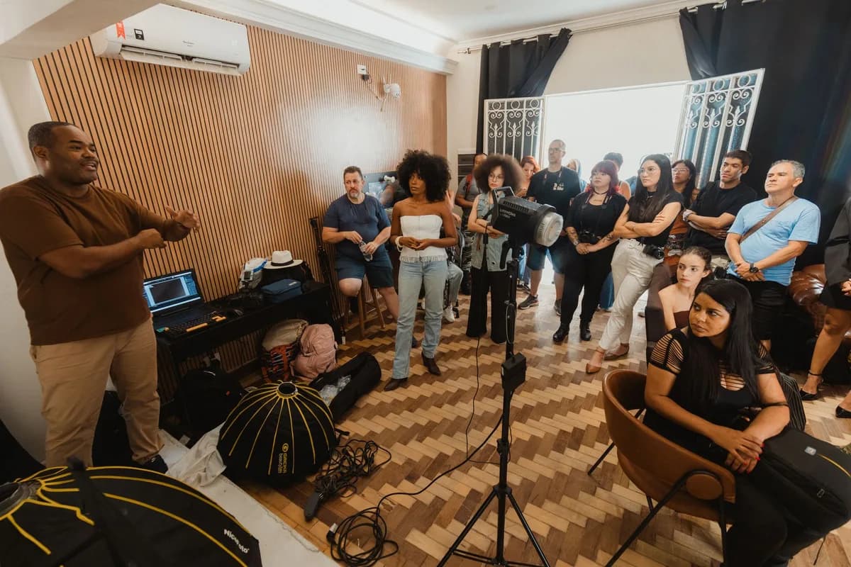A group of adults attending a photography workshop indoors, featuring lighting equipment and informal setting.
