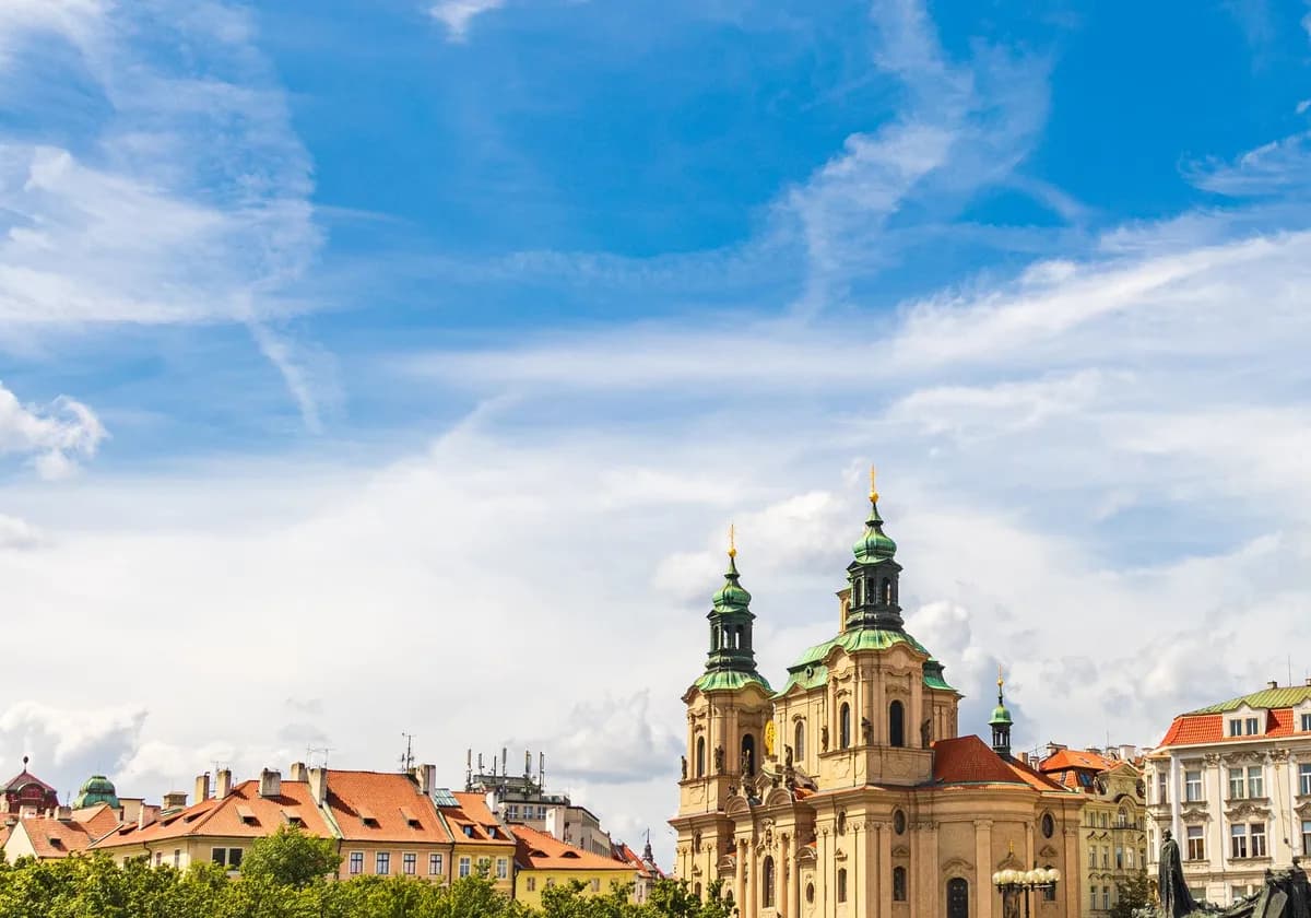 Exterior of aged Saint Nicholas church placed in Prague under cloudy blue sky in sunny day