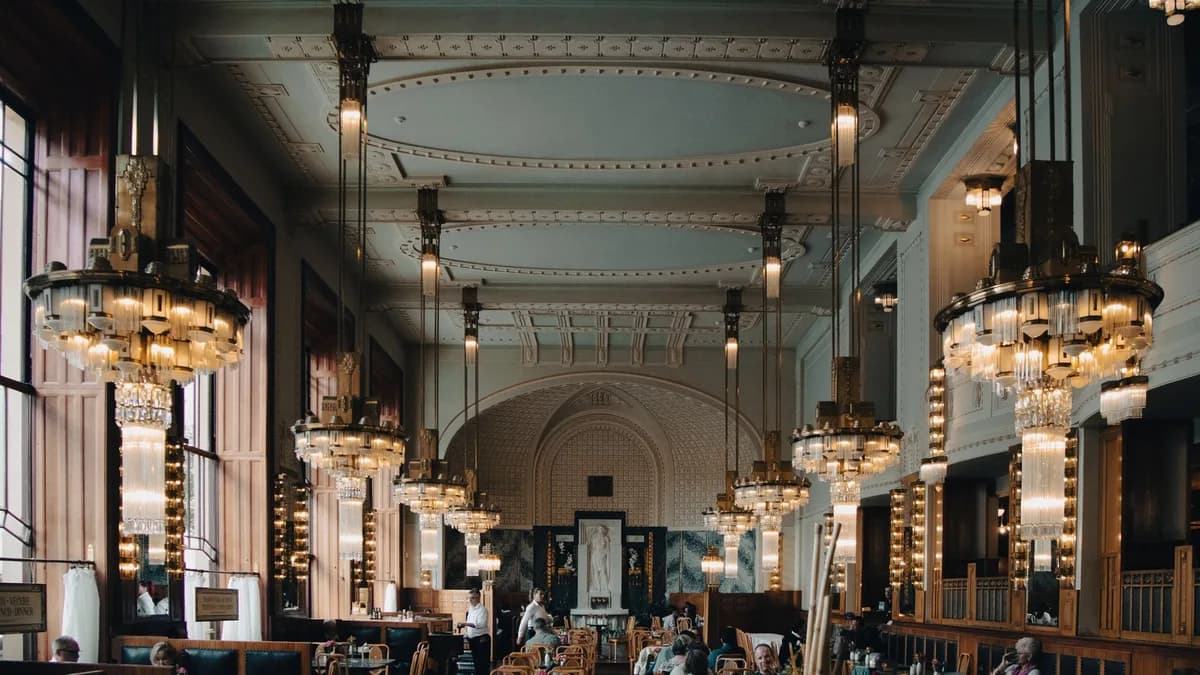 Elegant Art Deco chandeliers and classic architecture inside a Prague café.