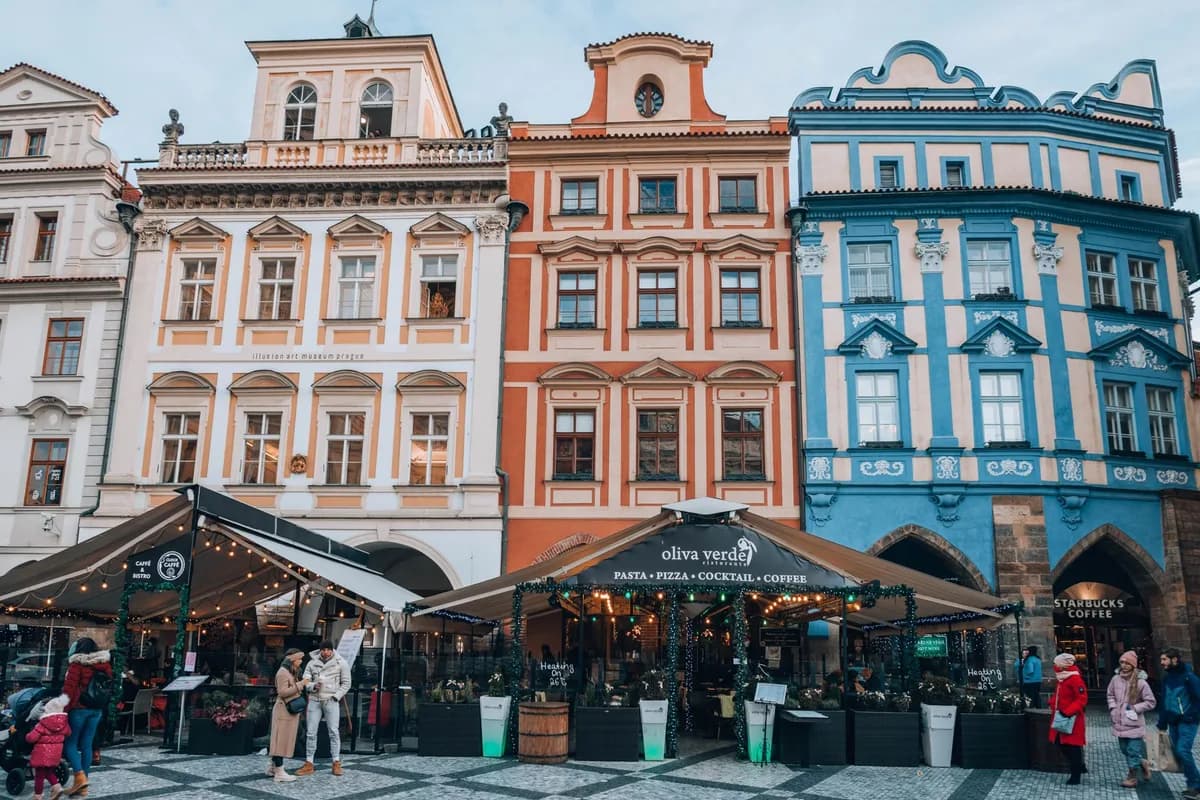 Charming European street with colorful facades and lively cafés bustling with people.