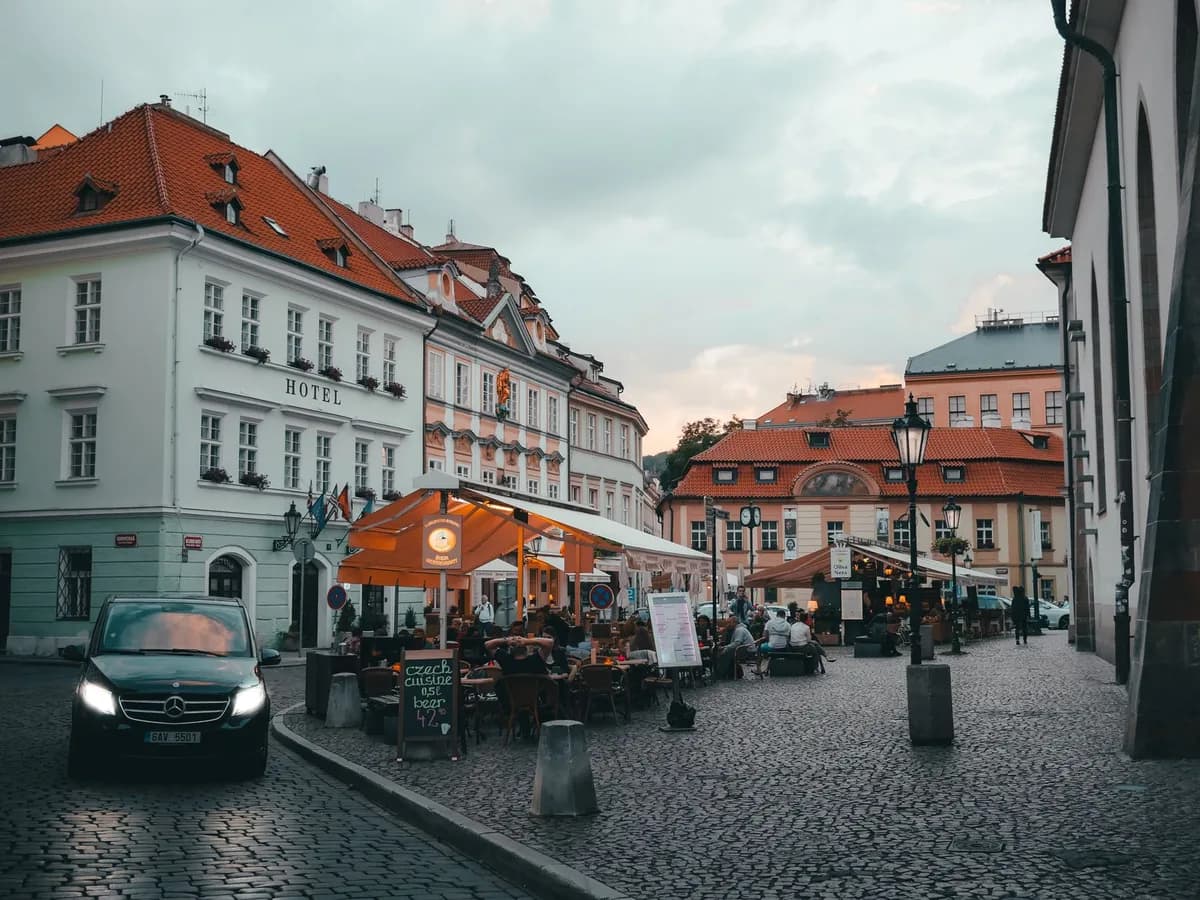 A picturesque evening view of a bustling cafe corner in Old Town Prague, Czechia.