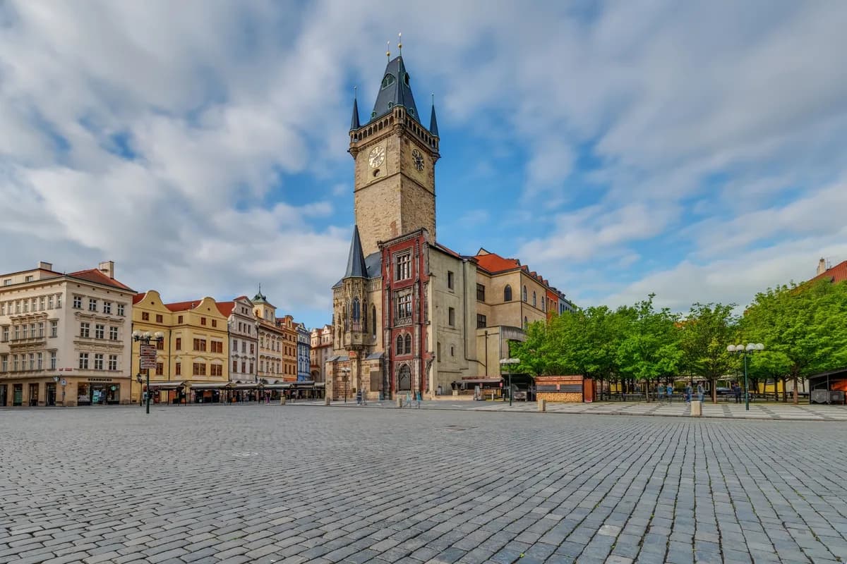 Scenic view of the iconic Old Town Square in Prague featuring historic architecture and the town hall tower.