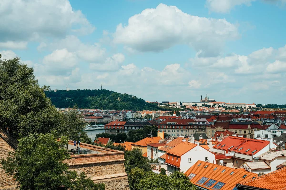 A vibrant view of Prague's historic rooftops under a bright blue sky.