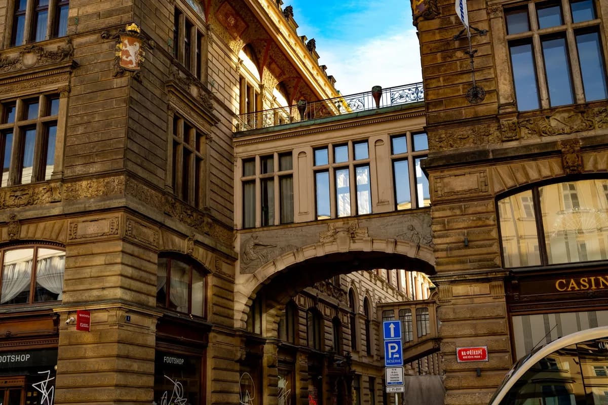 A stunning view of historic buildings and a sky bridge in Prague, highlighting intricate architectural details under clear skies.