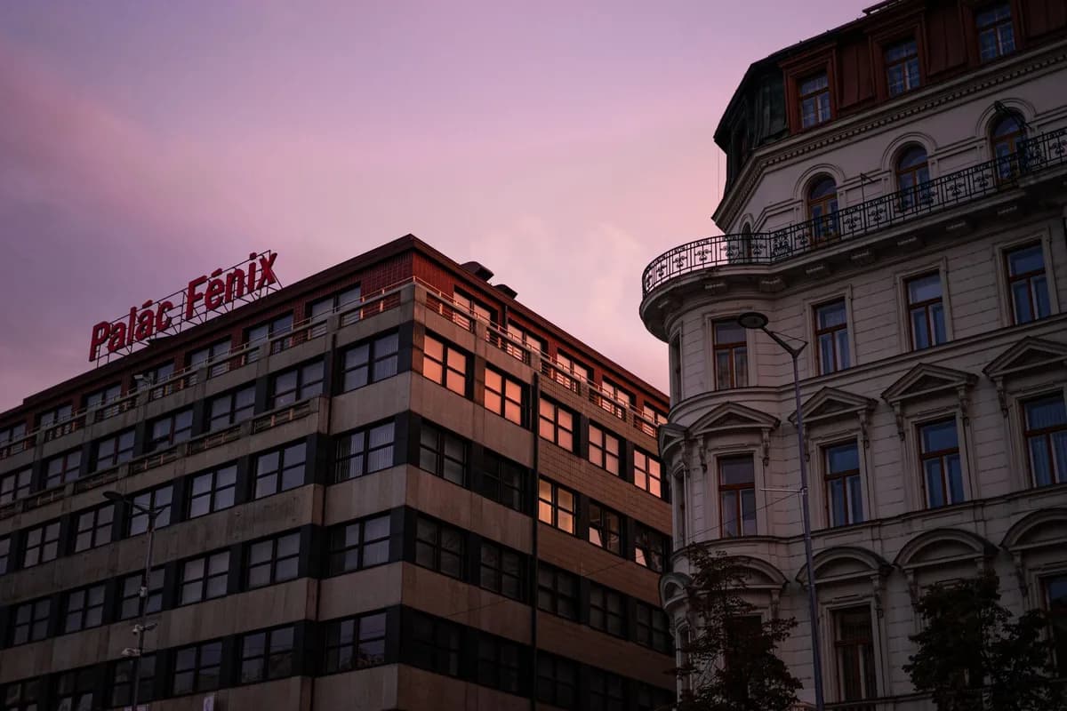 Twilight cityscape showing Palac Fenix buildings with architectural details under a warm sky.