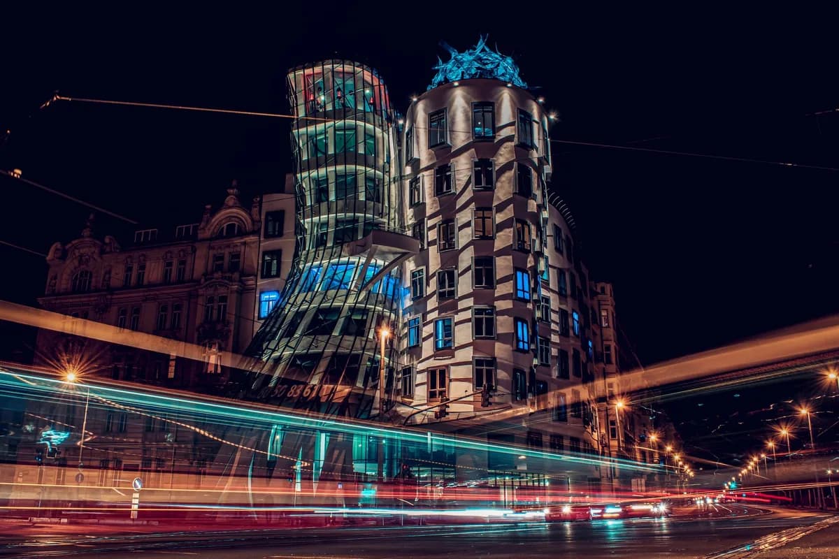 The illuminated Dancing House in Prague with vibrant light trails creating a dynamic night cityscape.