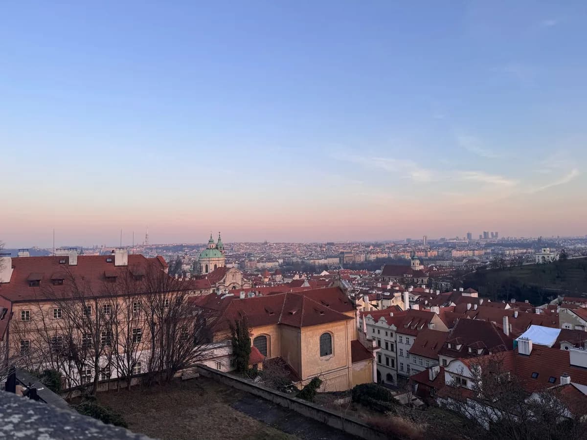Breathtaking sunset view of Prague's historic rooftops and skyline.