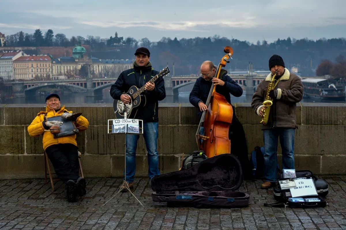 Group of street musicians entertaining passersby on Charles Bridge in Prague, Czechia.