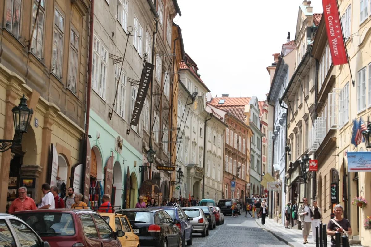 Busy European street with vintage architecture and pedestrians under clear skies.